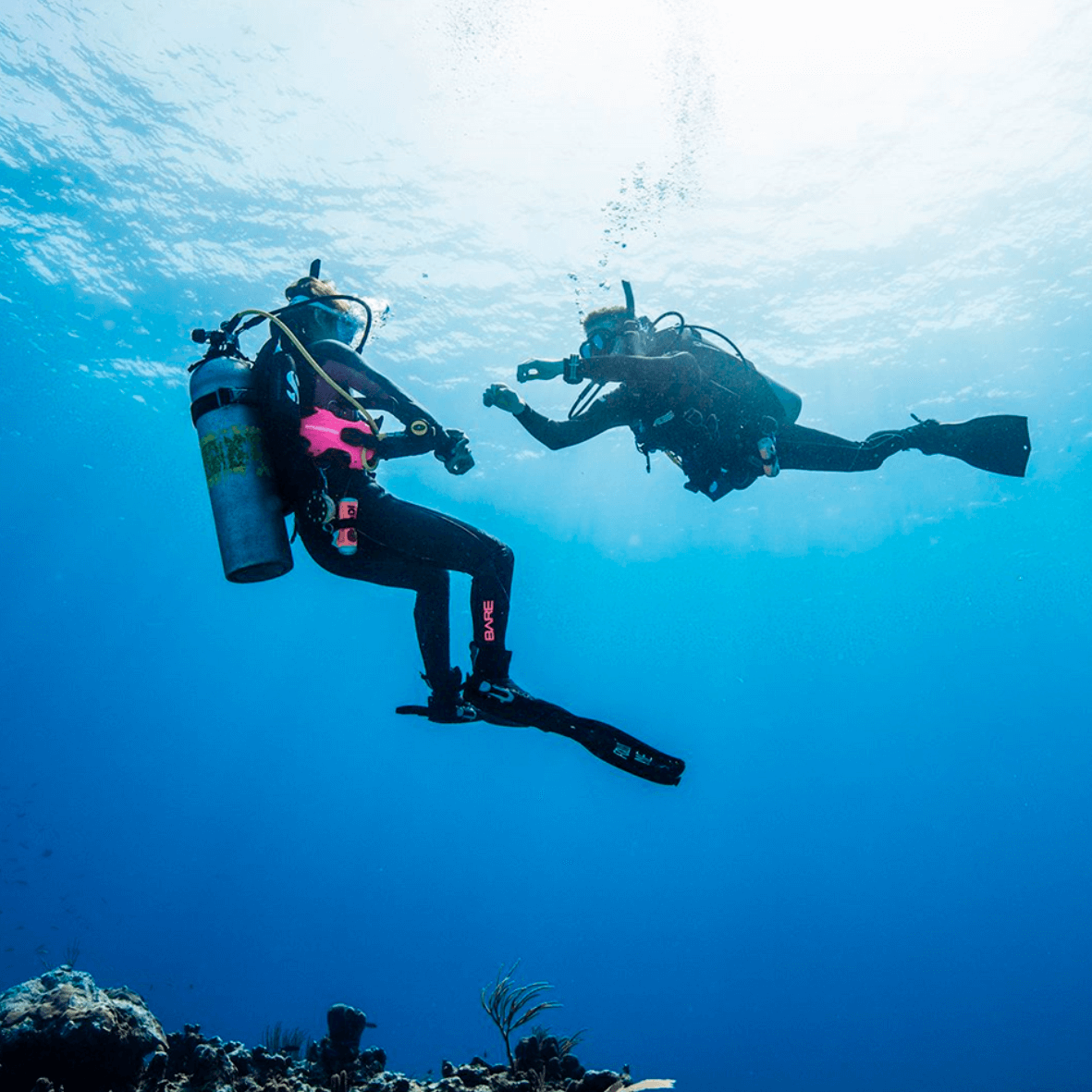 Diver exploring colorful coral reef near Santa Marta, Colombia with tropical fish and clear blue water