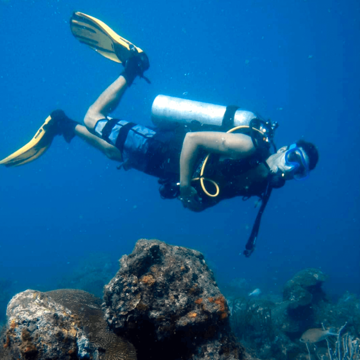 Professional scuba diving equipment set on boat deck: tanks, BCD, and regulator ready for Caribbean diving