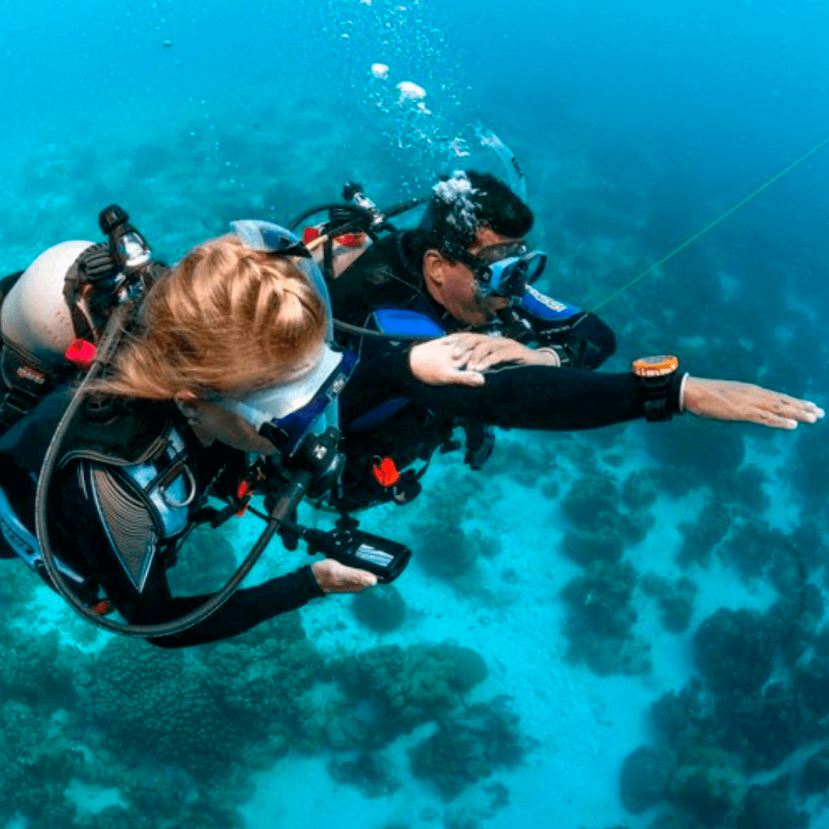 Buzo nadando junto a arrecife de coral colorido con peces tropicales en Santa Marta, Colombia