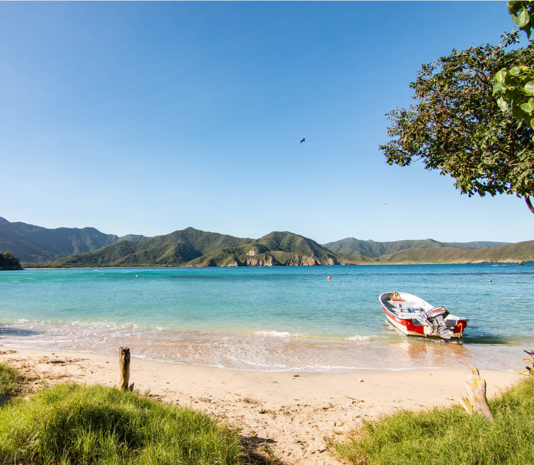 Panoramic view of Playa Cristal's crystal-clear turquoise waters and white sand beach surrounded by lush jungle in Tayrona National Park