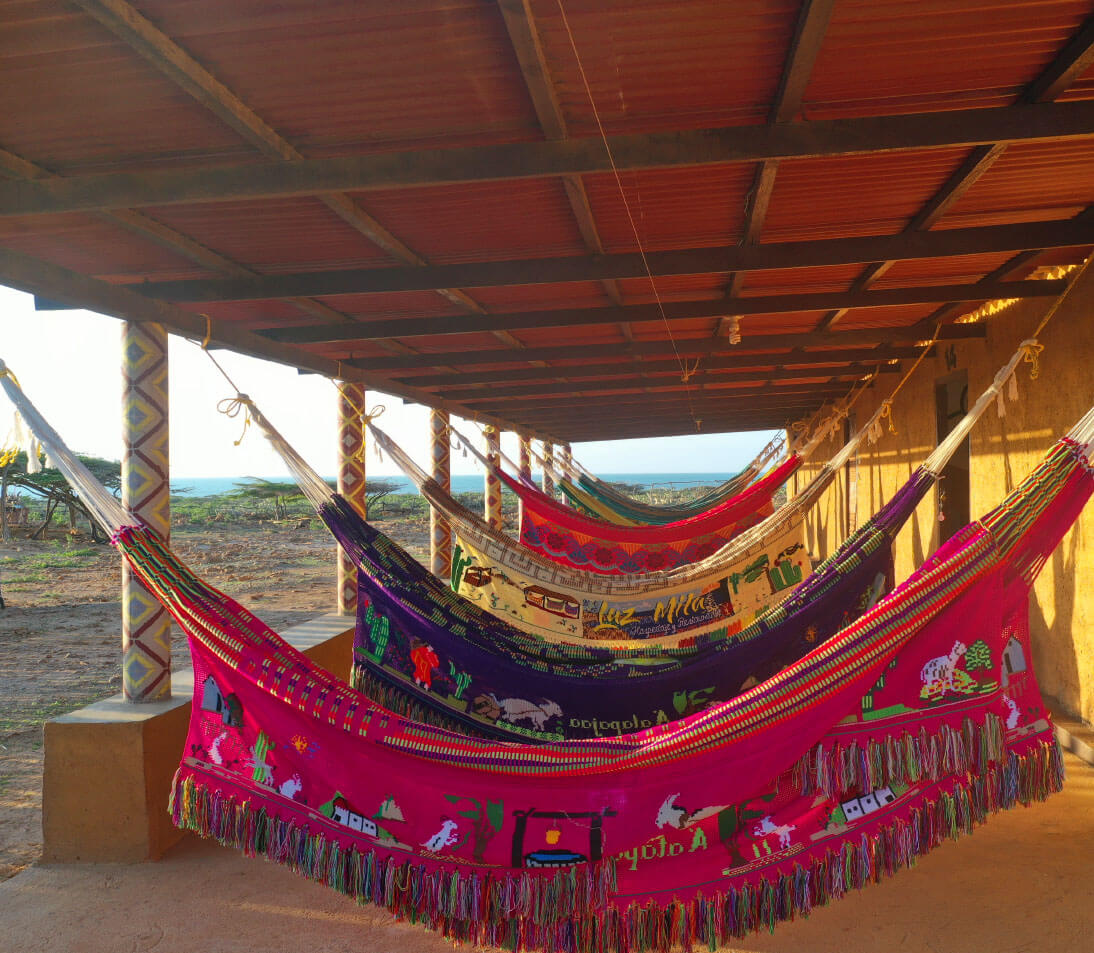 Vast desert landscape of Punta Gallinas with red sand dunes meeting the turquoise Caribbean Sea under a clear blue sky
