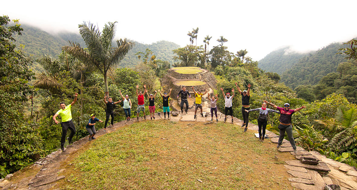Teyuna Tours' Essence - Sustainable Adventure Travel in Colombia Diverse team of Teyuna Tours guides smiling in Tayrona National Park with backpacks
