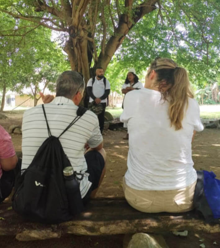 Arhuaca indigenous guide and local interpreter explaining traditions to tourist group in Katanzama community
