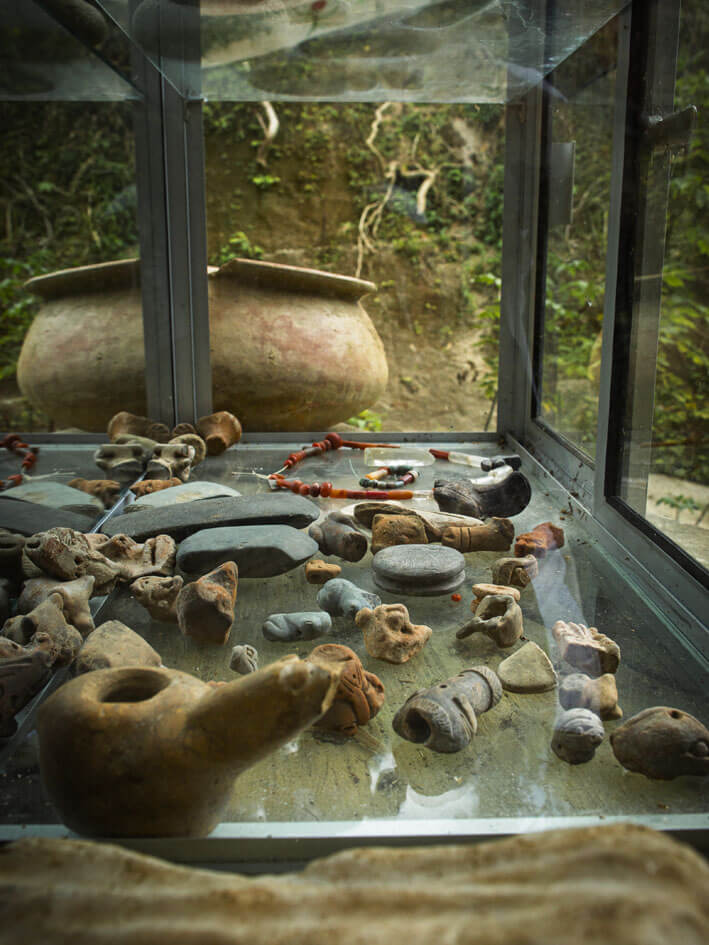 Display case with ancient Tayrona ceramic utensils and artifacts at Bunkuany archaeological site