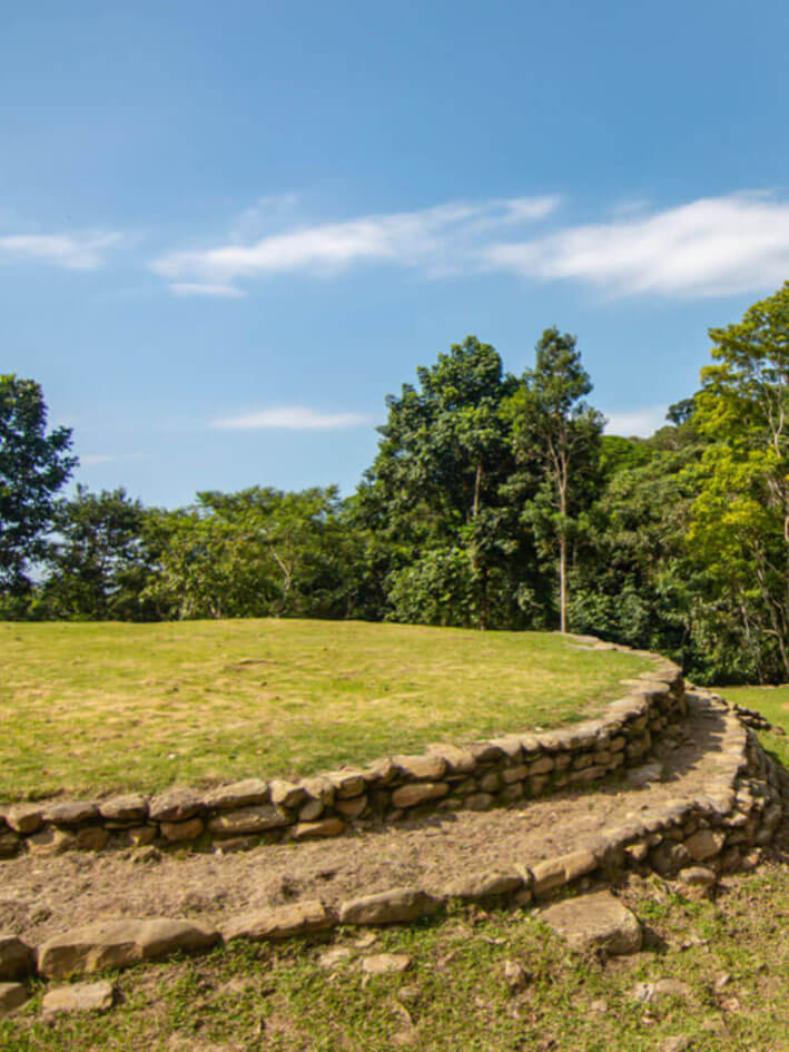 Tourist group waving to drone camera while hiking mountain trail in Seyviaka indigenous territory, Sierra Nevada de Santa Marta